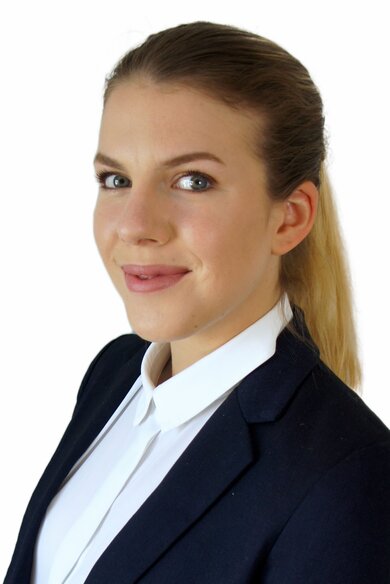 Porträt braunhaarige, lächelnde Frau. Blauer Blazer und Hemd. 