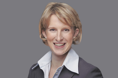 Porträt blonde, lächelnde Frau mit Hemd und Blazer. Bobhaarschnitt. 