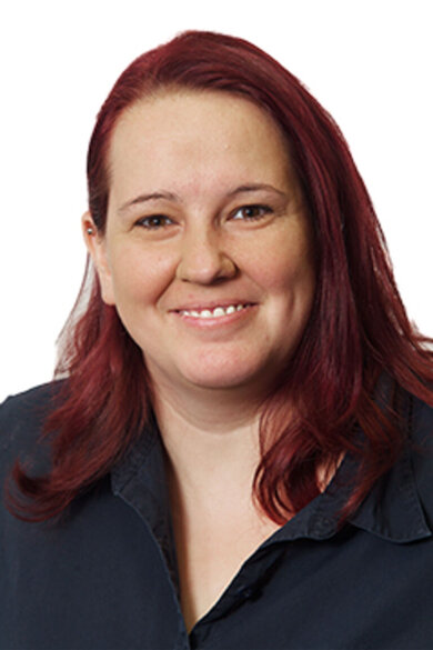 Porträt lächelnde Frau. Rot-braune, offene Haare.