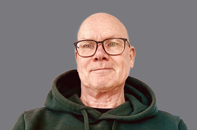 Porträt: Lächelnder Mann mit Brille in grünem Hoodie