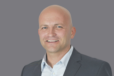 Porträt lächelnder Mann in einem dunklen Anzug mit hellemHemd