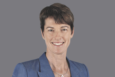 Porträt bruanhaarige, lächelnde Frau. Blauer Blazer, kurze Haare. 