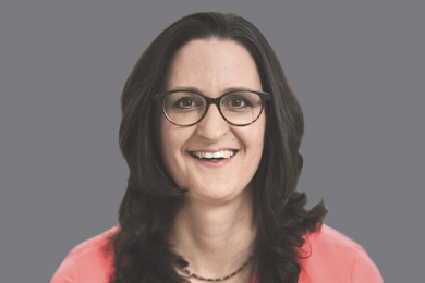 Porträt braunhaarige, lachende Frau mit Brille.