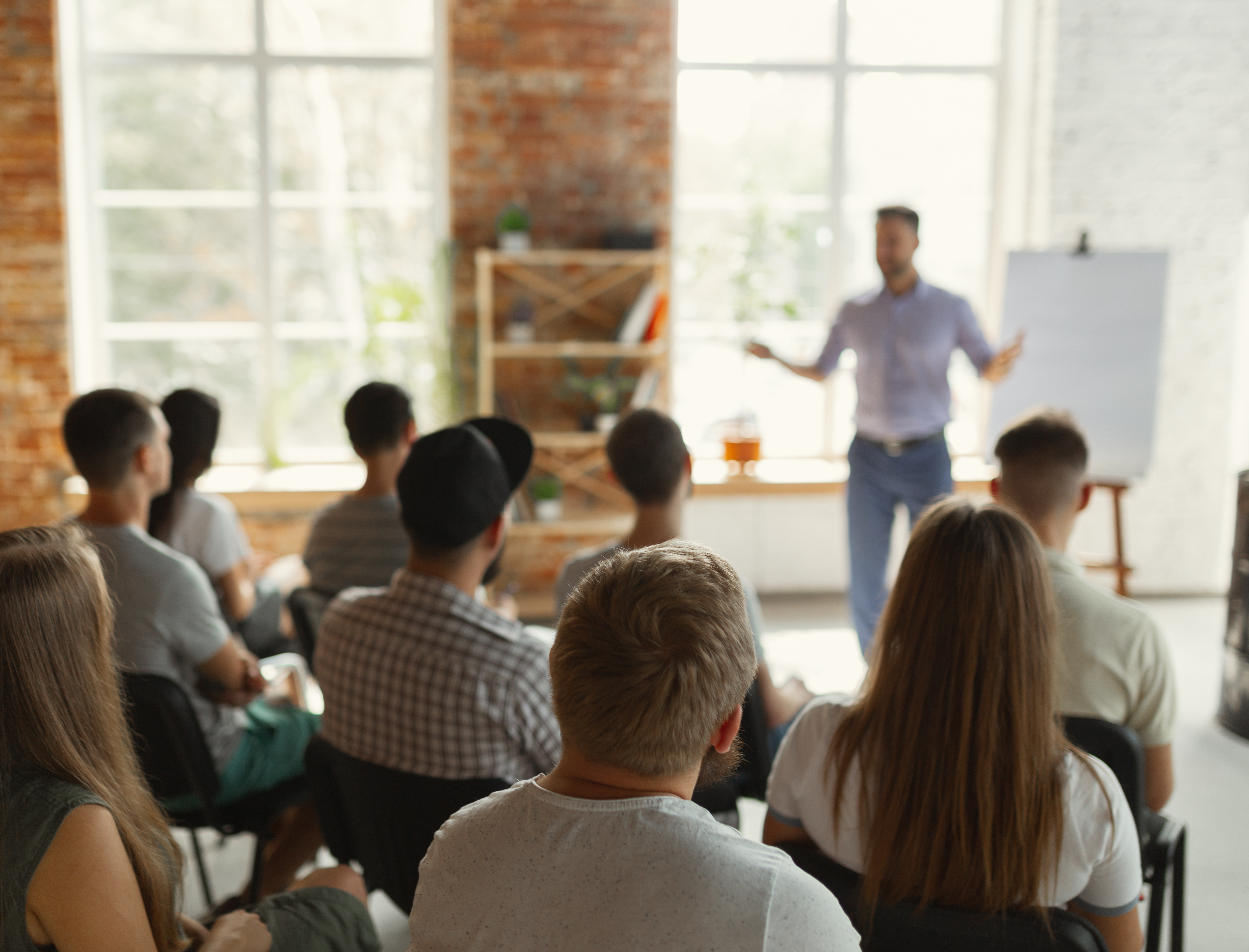 Mann steht vor Gruppe an Flipchart