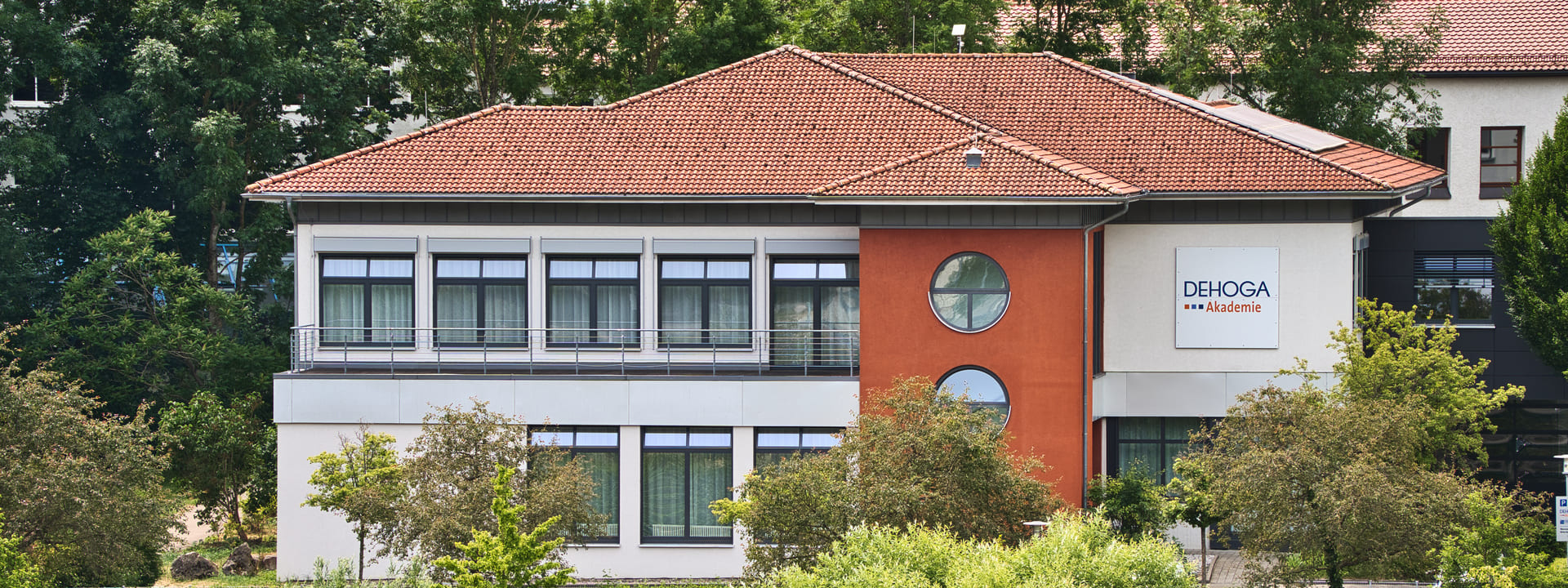 Ein einstöckiges Gebäude mit DHEOGA Akademie Logo