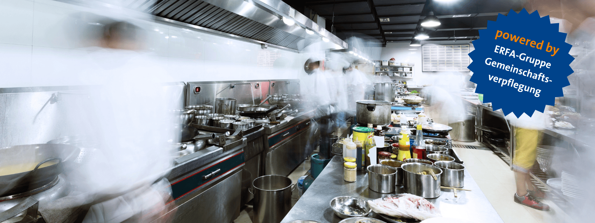 Blick in eine große Küche mit blauem Stern oben rechts in der Ecke. in diesem steht: ,,powered by ERFA Gruppe Gemeinschaftsverpflegung''