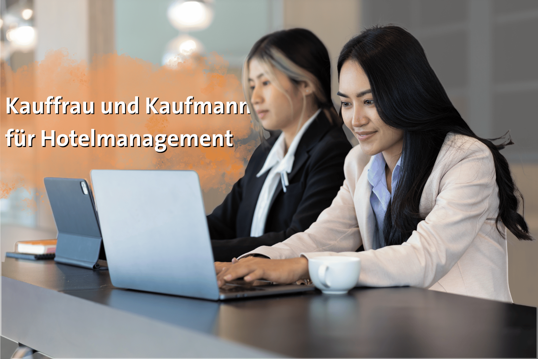 Zwei Mitarbeiterinnen sitzen an ihre Laptops an einem Tisch ud arbeiten