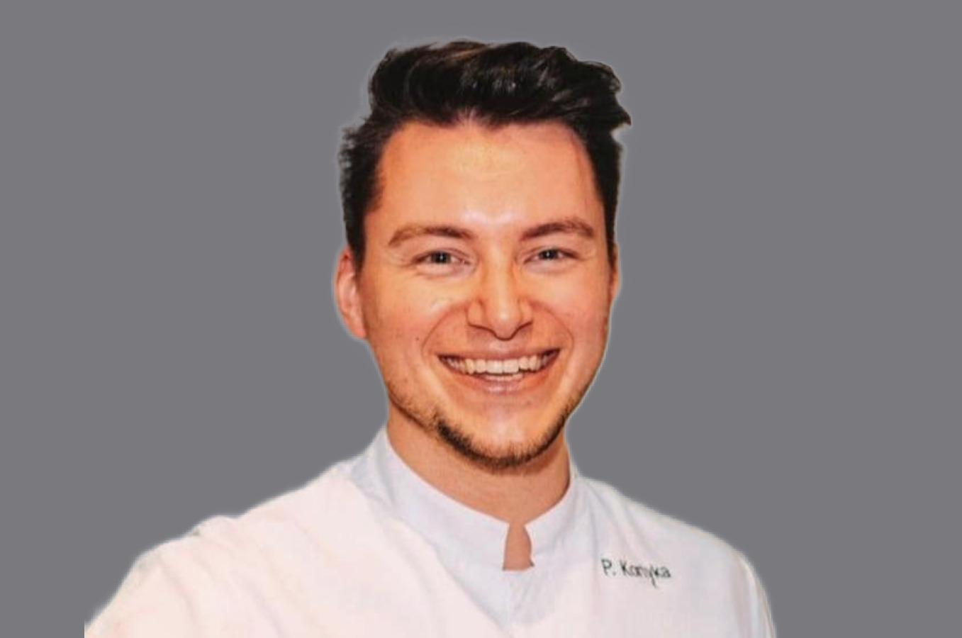 Lachender, braunhaariger Mann in Kochjacke