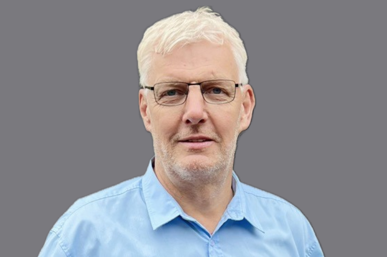 Mann in blauem Hemd mit Brille und weißen Haaren 