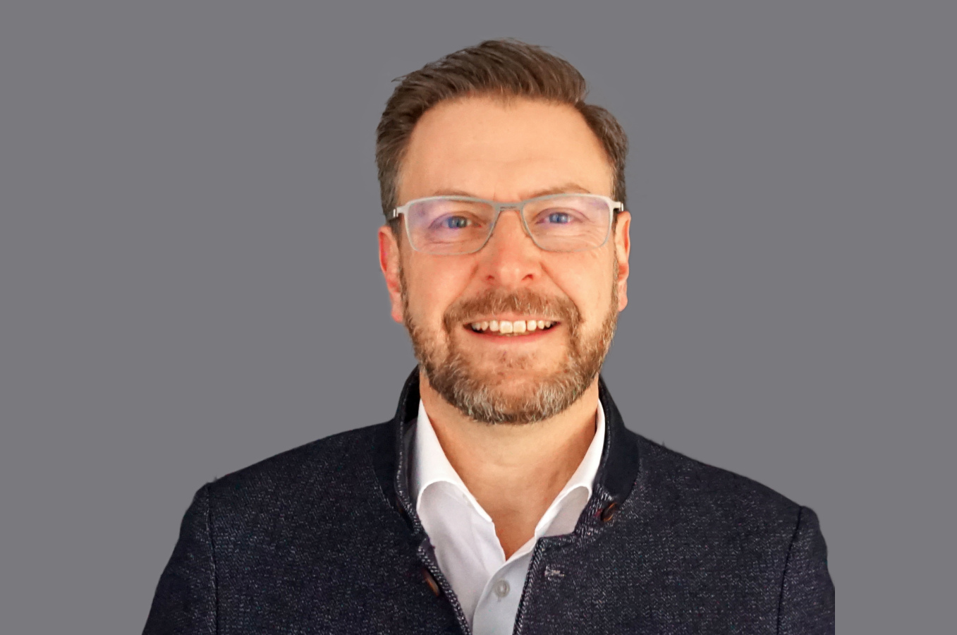 Lachender, braunhaariger Mann mit Brille